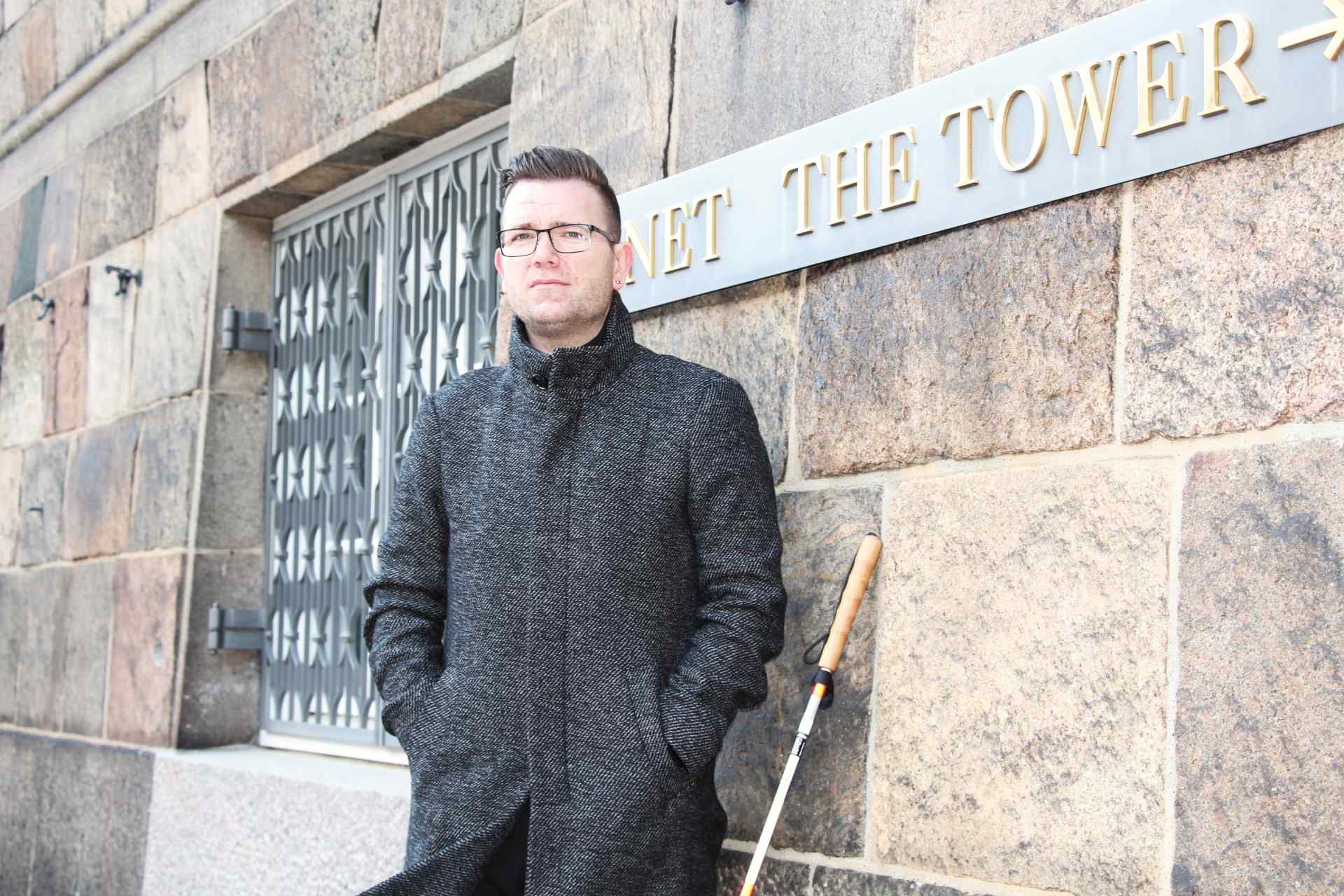 Formand for DøvBlinde Danmark Jackie Lehmann Hansen foran skilt ved Christiansborg