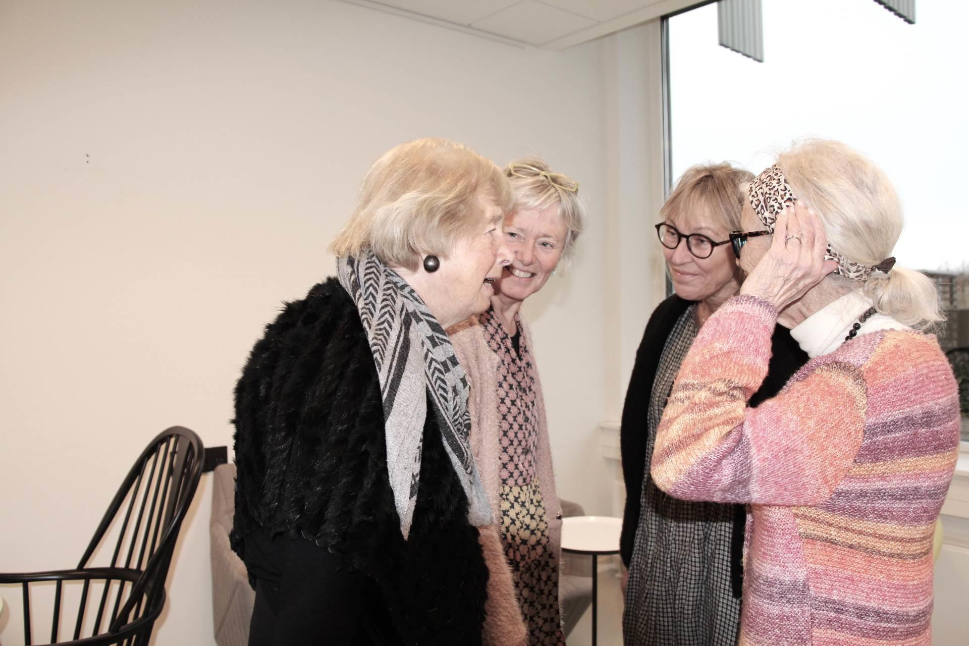 Fire kvinder snakker sammen og lytter intenst