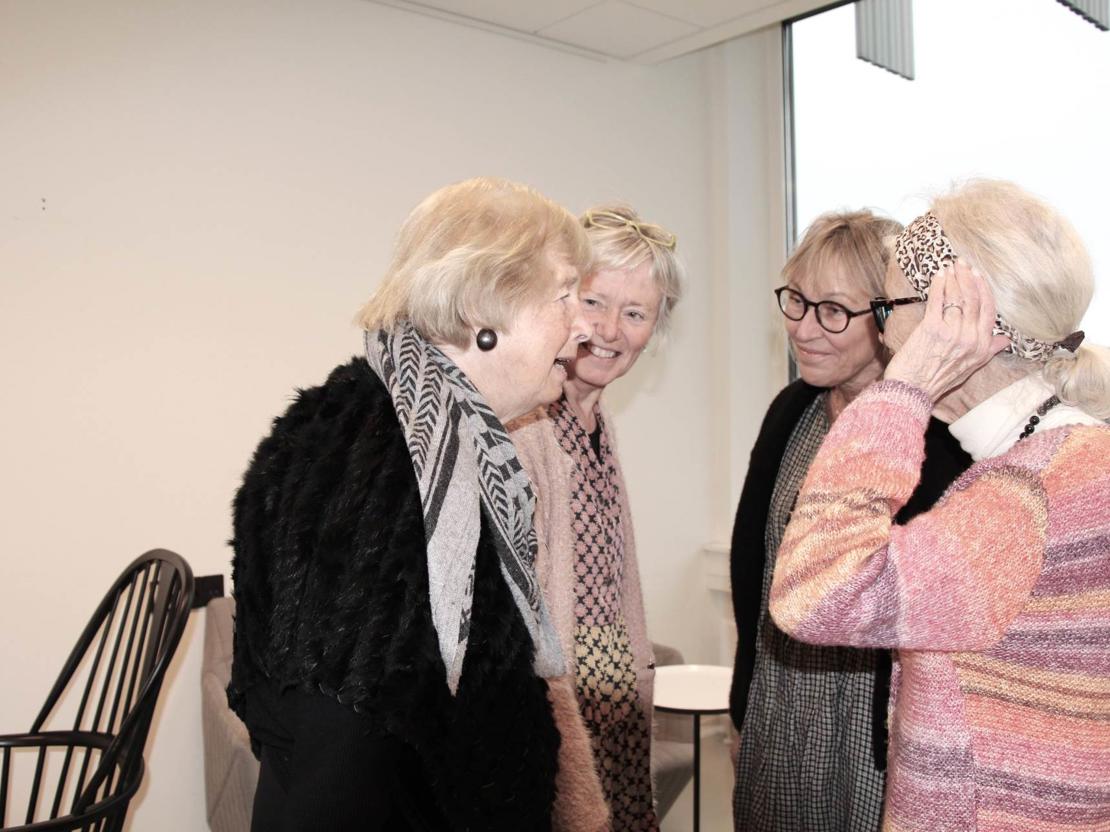 Fire kvinder snakker sammen og lytter intenst
