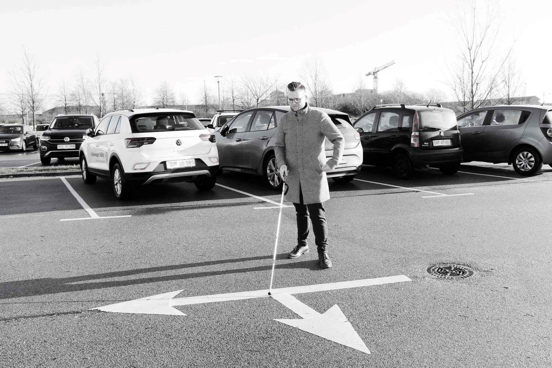 Formanden ser på pile på vejbanen med hvid stok