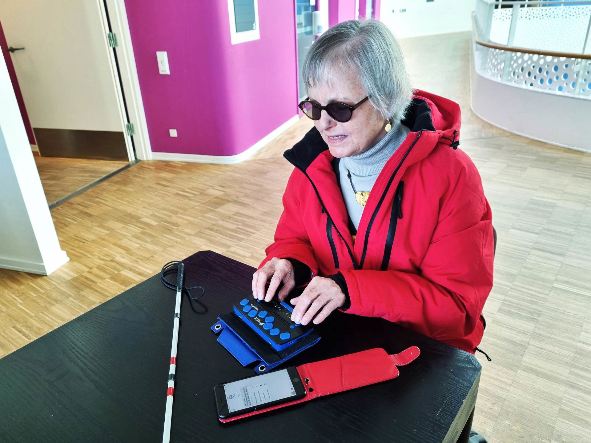 Døvblind kvinde med punkttastatur koblet trådløst til mobil