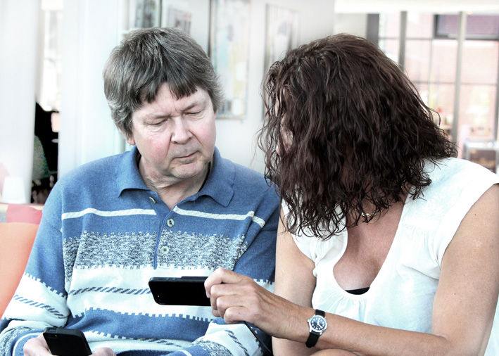 To døvblinde ser på mobil sammen