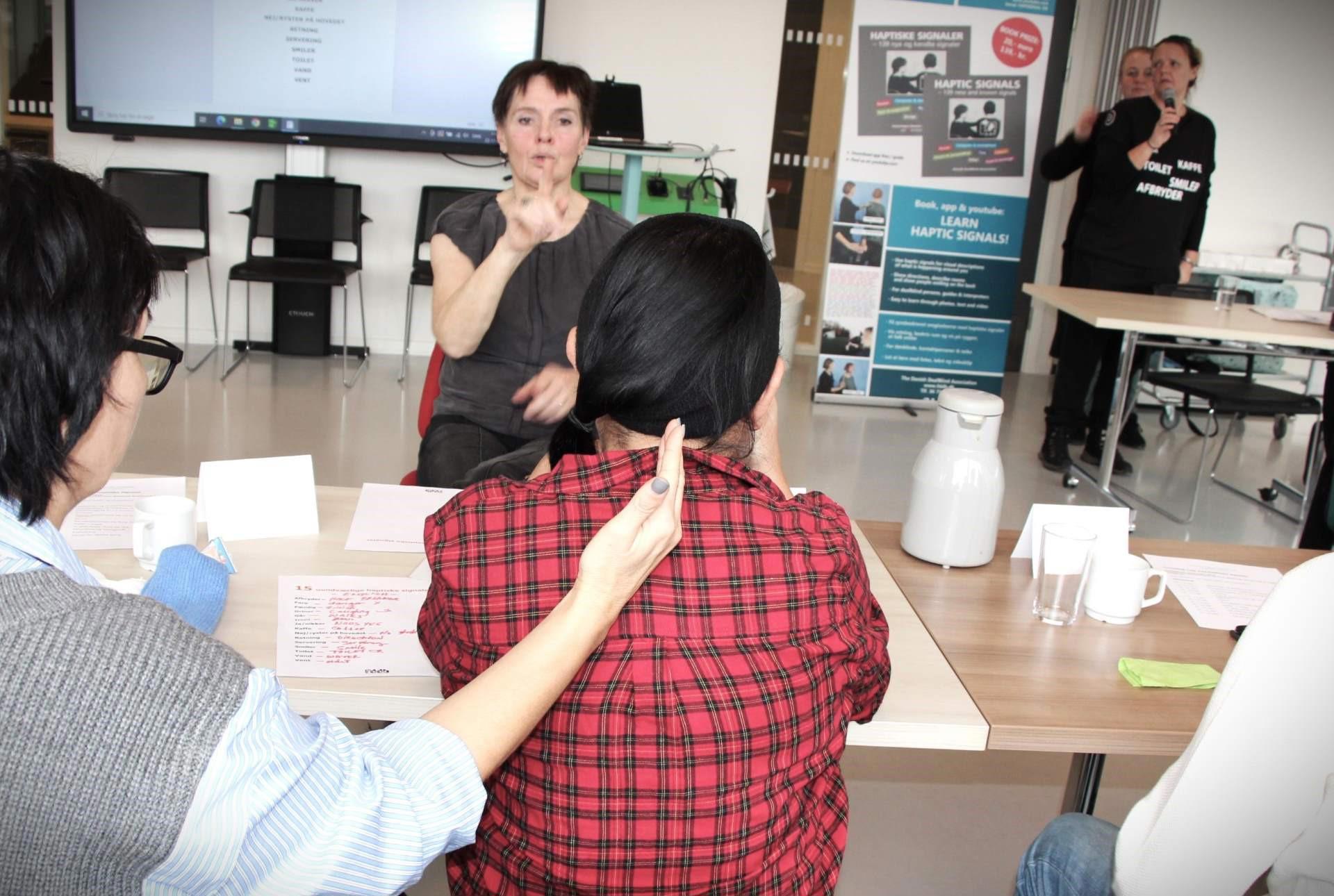 Døvblind kvinde får det haptiske signal på ryggen for Retning