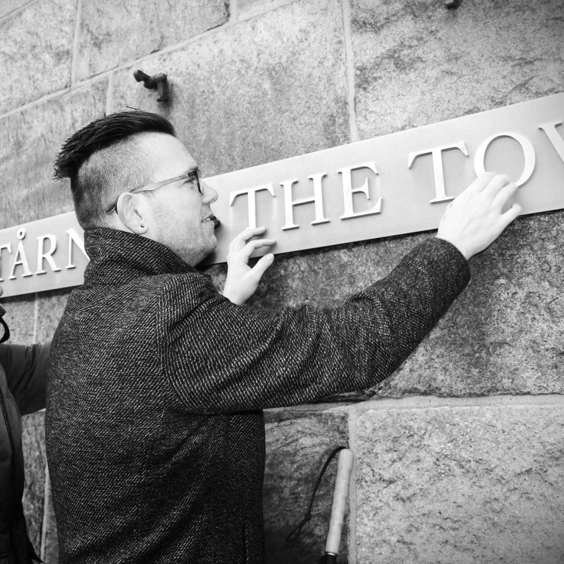 Formand for DøvBlinde Danmark Jackie Lehmann Hansen aflæser et følbart skilt med hænderne foran Christiansborg