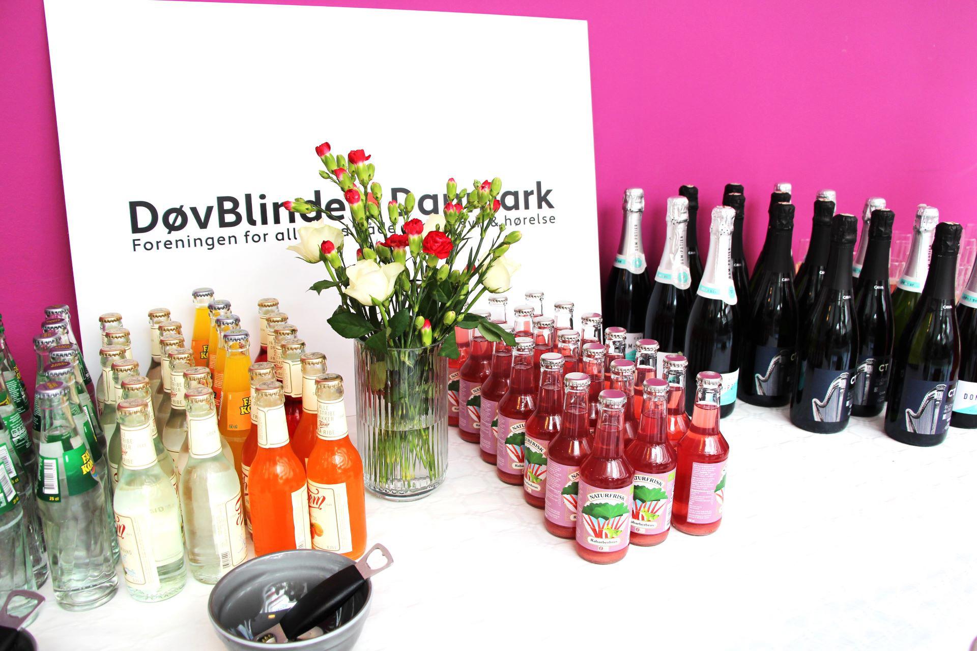 Cava, sodavand og blomster foran det nye logo