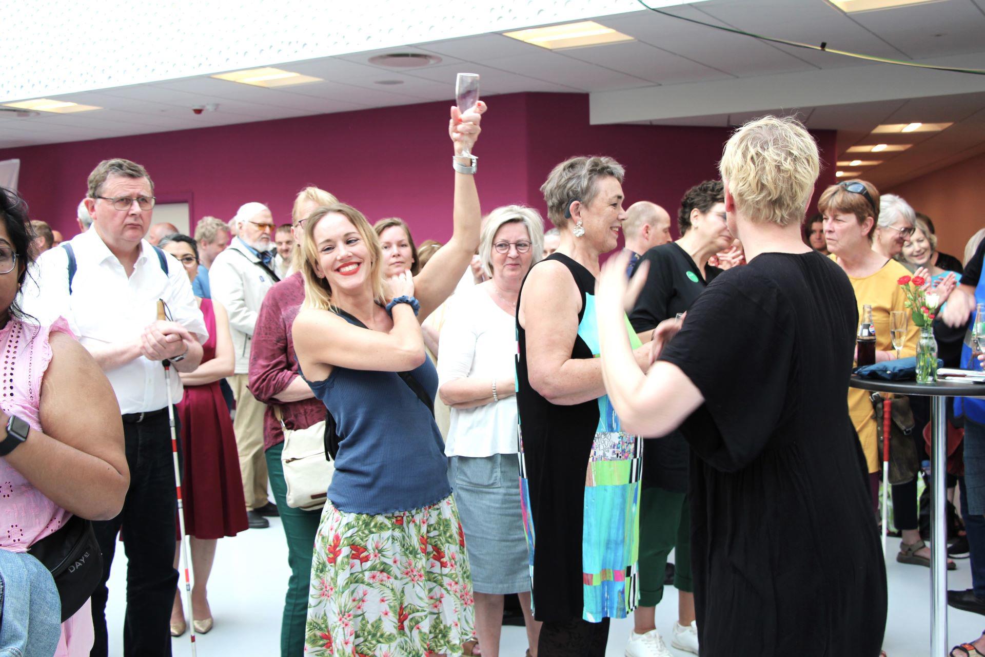 Medlemmer og gæster skåler og smiler