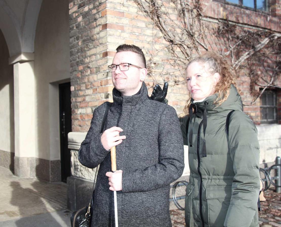 Haptiske signaler laves på skulderen af en døvblind, mens kontaktpersonen samtidig synsbeskriver