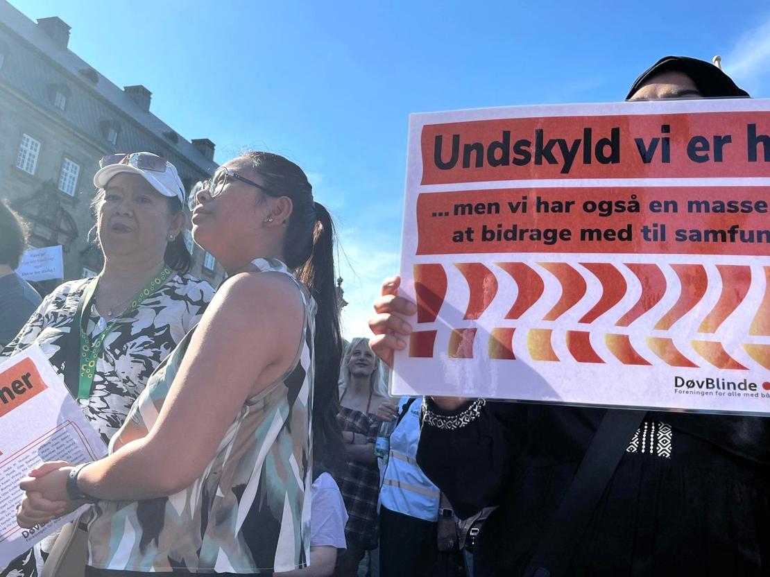 Demonstration hvor døvblinde står med skilt: Undskyld vi er her
