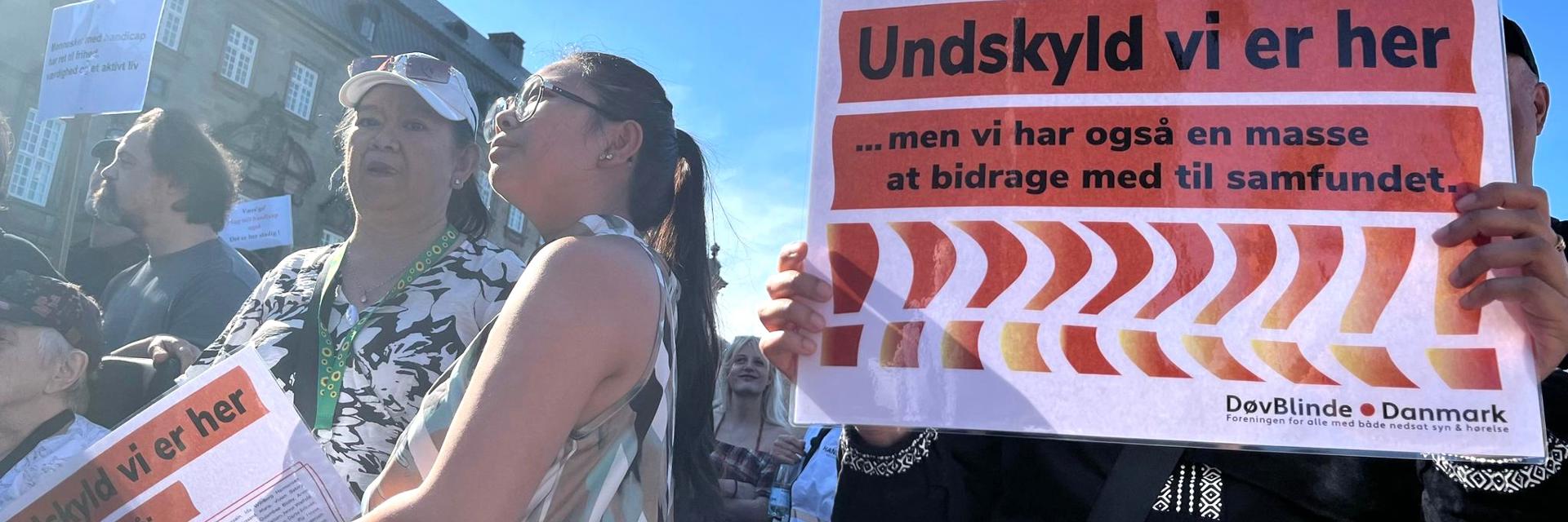 Demonstration hvor døvblinde står med skilt: Undskyld vi er her