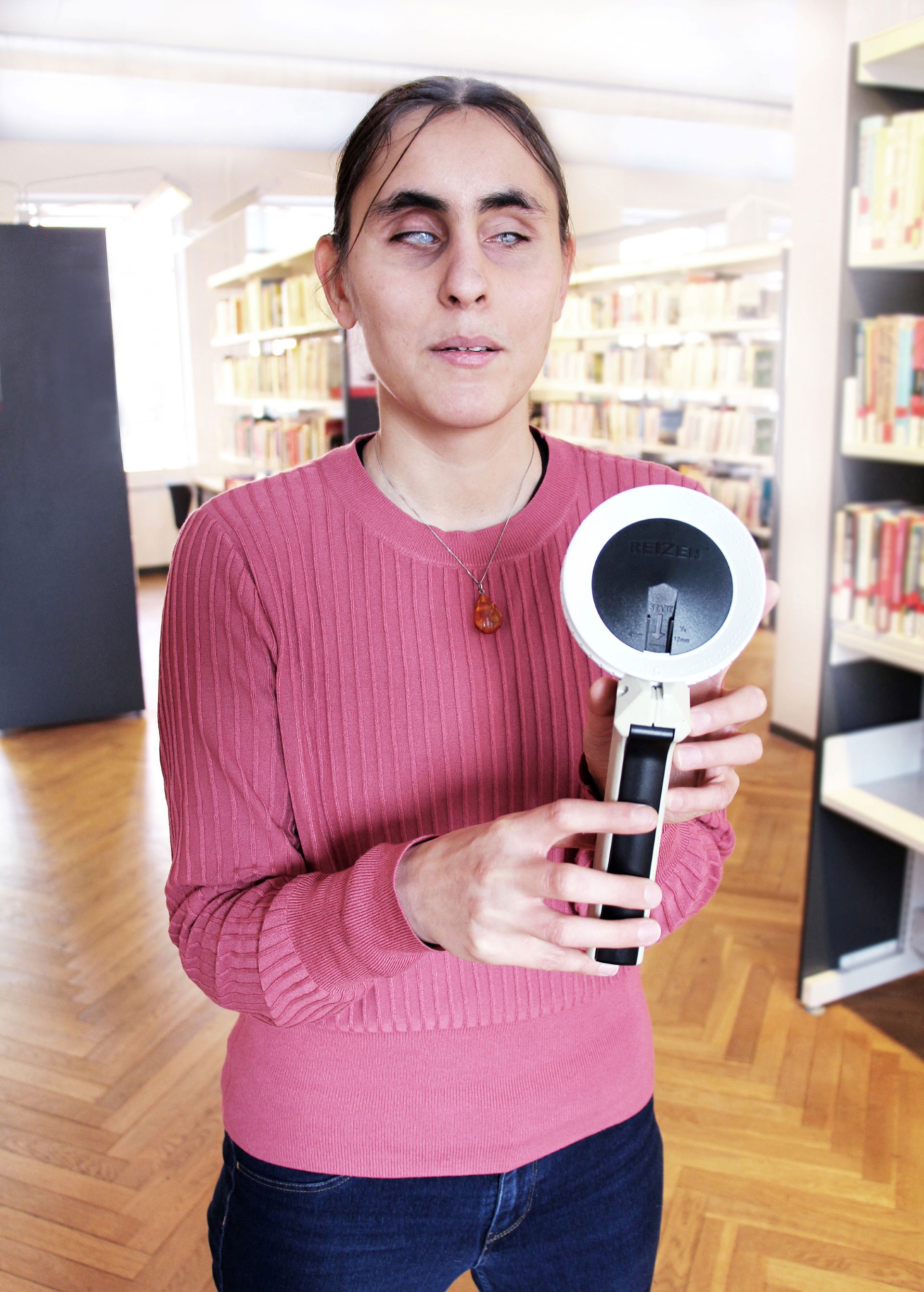 Døvblind kvinde viser dymolabel-maskine